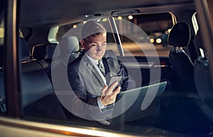 Businessman using his mobile phone while traveling of the car