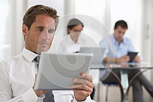 Businessman using his tablet in the office