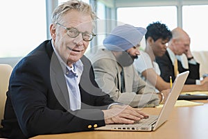 Businessman Using Laptop Besides Multiethnic Colleagues