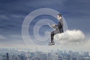 Businessman using laptop on the cloud