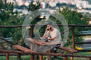 Businessman using a laptop computer against beautiful landscape