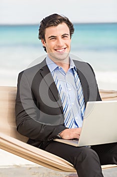 Businessman using laptop on the hammock