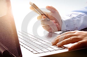 Businessman using laptop and mobile phone