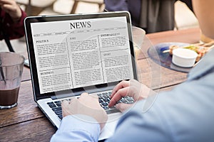 Businessman using laptop reading news article on the laptop / computer screen