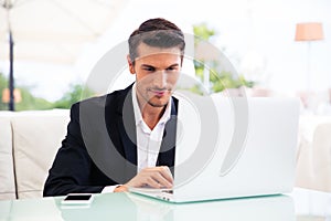 Businessman using laptop in restaurant