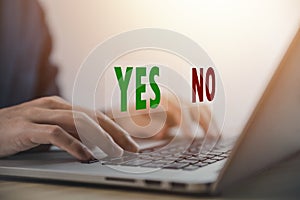 Businessman using laptop showing right and wrong sign have an idea to decide to vote think yes or no Business options for