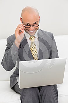 Businessman using laptop on sofa at home