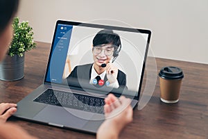 Businessman using laptop on table with making video call meeting to customer support phone operator