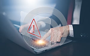 Businessman using laptop with triangle caution warning sign for notification error, Spam Email Pop-up Warning