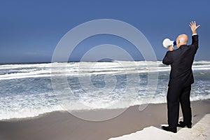Businessman Using Megaphone On Beach