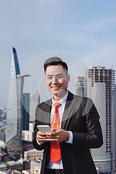 Businessman using mobile phone app texting outside of office