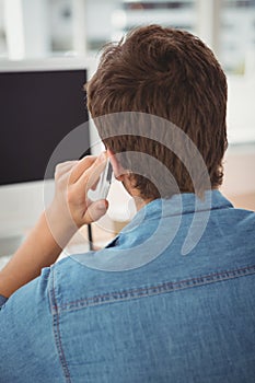 Businessman using mobile phone at desk in office