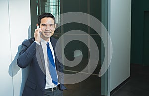 Businessman using mobile phone indise office building,after work