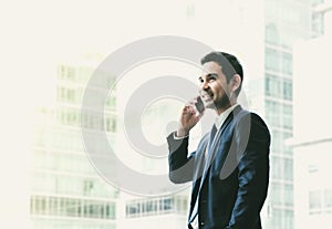 Businessman using mobile phone near office window at office building,communication concept,vintage filter