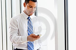 Businessman Using Mobile Phone In Office