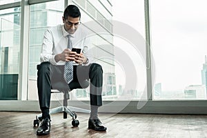 Businessman using a mobile phone while sitting down