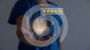 Businessman using a mobile phone to point to a smile face and five stars icon, representing positive reviews