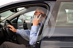 Businessman using mobile smart phone while driving the car