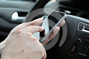 Businessman using mobile smart phone while driving the car