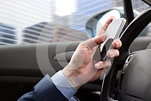 The businessman using mobile smart phone while driving the car