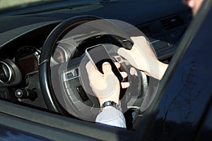 The businessman using mobile smart phone while driving the car