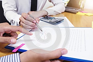 Businessman is using a pen for financial data analyzing counting