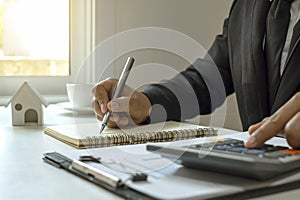 businessman using a pen to take notes Including a calculator