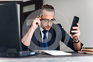 Businessman using phone while working In office