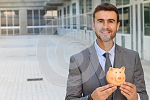 Businessman using a piggybank to save money