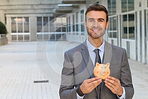 Businessman using a piggybank to save money