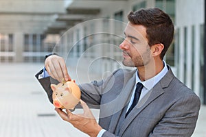 Businessman using a piggybank to save money