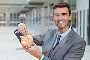 Businessman using a piggybank to save money