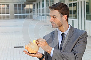 Businessman using a piggybank to save money