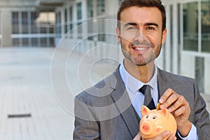 Businessman using a piggybank to save money