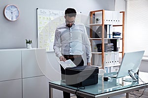 Businessman Using Printer In Office