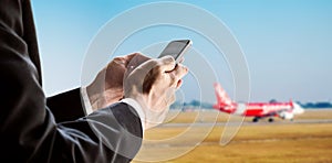 Businessman using smart phone with airplane background, concept of online checking in, mobile on plane and etc.