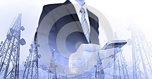 Businessman using smart phone with double exposure panoramic city and telecommunication towers