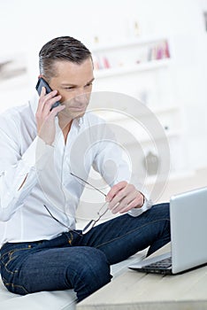 Businessman using smart phone and laptop