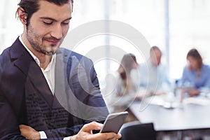 Businessman using smart phone in meeting room