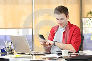 Businessman using smart watch and mobile phone
