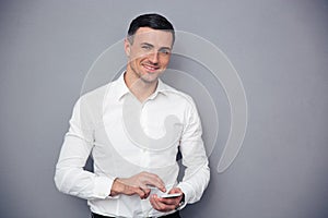 Businessman using smartphone over gray background