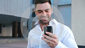 Businessman Using Smartphone and Reacting to Success. Handsome professional successful business man reaching personal