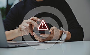 Businessman using smartphone with warning sign