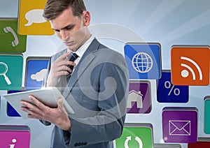 Businessman using tablet against applications icons