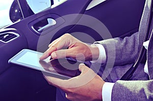 Businessman using a tablet in a car