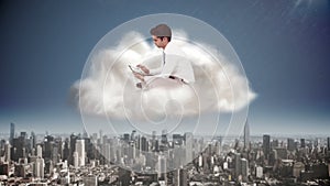 Businessman using tablet in cloud over city