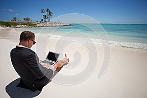 Businessman using tablet computer on the beach