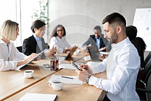 Businessman Using Tablet Computer At Corporate Meeting In Modern Office
