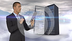 Businessman using tablet computer in front of server tower on sky background
