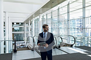 Businessman using tablet computer in office lobby